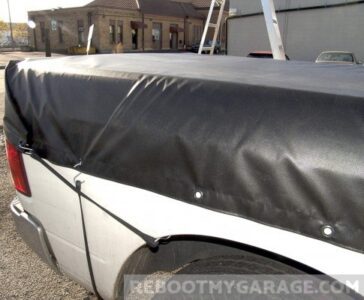Black lawn tractor tarp wrapped on truck