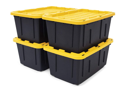 Four black plastic garage storage bins with bright yellow lids, stacked two high