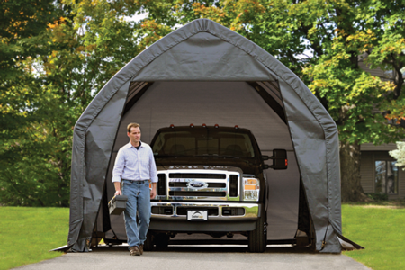 A man standing in front of a Ford pickup truck parked inside a ShelterLogic Garage-in-a-Box